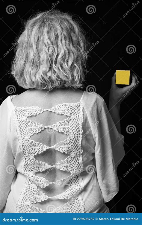 A Blond Woman Seen From The Back In An Embroidered Crochet Shirt Is