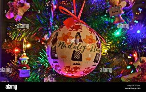 Brightly coloured Christmas tree decorations,one with a Welsh Lady in ...