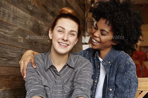 Stylish Young Interracial Lesbian Couple Enjoying Time Together Hugging And Cuddling During