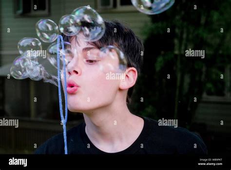 Teenage Boy Blowing Soap Bubbles Stock Photo Alamy