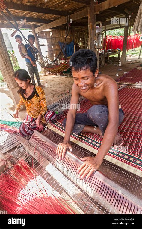 Phnom Penh Cambodia A Man And A Woman Weave Brightly Colored Straw On