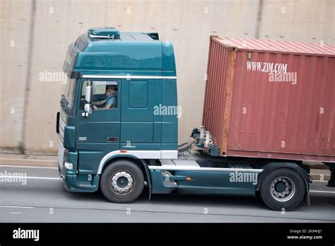 A Green Daf Xf Truck Loading A Red Container Trailer Along Barcelona S