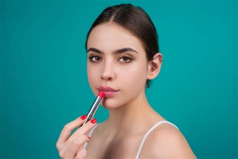 Premium Photo Beautiful Young Woman Applying Red Lipstick On Lips