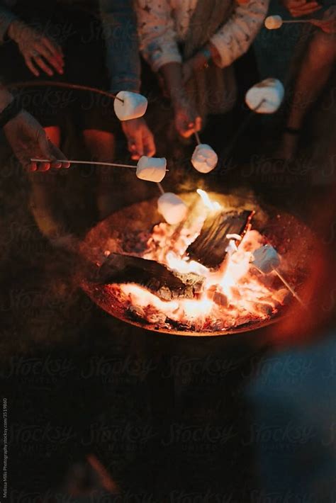 Friends Roasting Marshmallows At Night By Stocksy Contributor