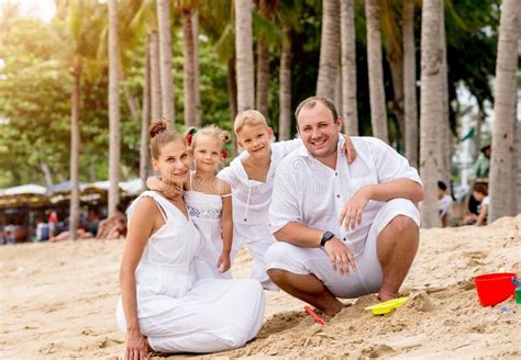 Feliz Familia Joven Al Atardecer En La Playa Imagen De Archivo