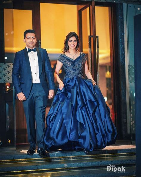 A Man And Woman In Formal Wear Standing On Steps