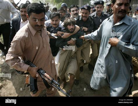 A Pakistani Police Officer Arrests One Of The Allegedly Gunmen At The