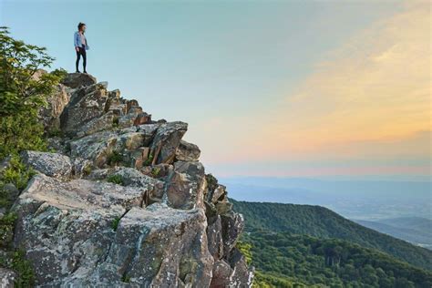 A Person Standing On The Edge Of A Cliff