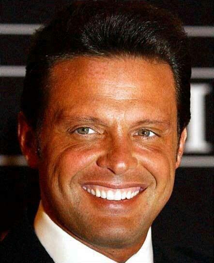 A Close Up Of A Person Wearing A Suit And Tie With A Smile On His Face