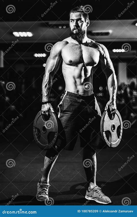 Athlete Muscular Bodybuilder Man Posing With Dumbbells In Gym Stock