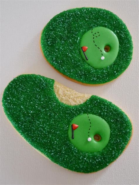 Two Decorated Cookies With Green Frosting And Golf Balls On Them One