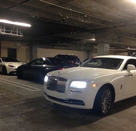 Two Rolls Royces Are Parked In A Parking Garage