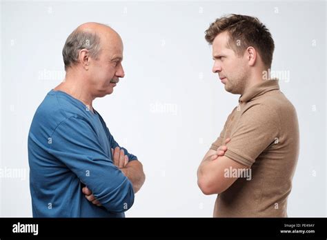 Mature Father And Son Looking On Each Other Face To Face They Quarreled To Make Claims And