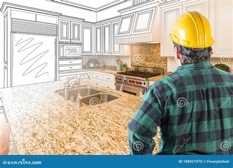 Male Contractor With Hard Hat And Tool Belt Looking At Custom Kitchen