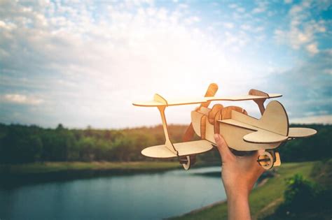 Premium Photo Cropped Hand Holding Model Airplane By Lake