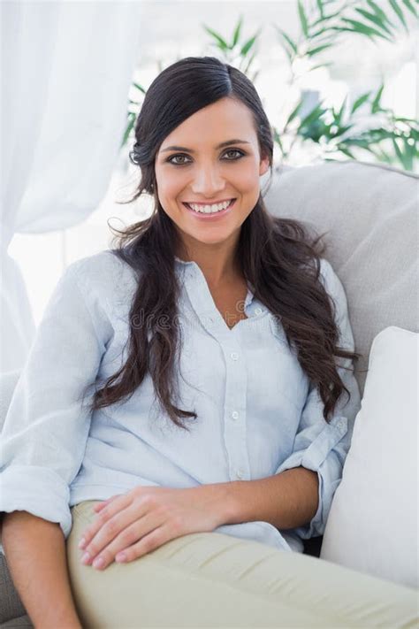 Smiling Gorgeous Brunette Sitting On The Couch Stock Photo Image Of Cheerful Beautiful