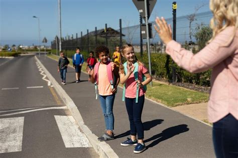 Premium Photo Female Teacher With Long Blonde Hair Waving To Schoolgirls