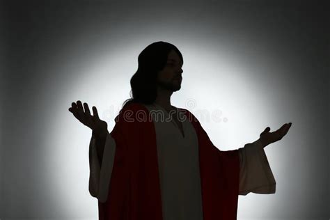 Silhouette Of Jesus Christ With Outstretched Arms On Color Background