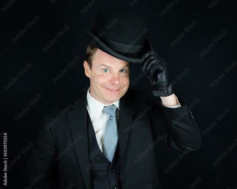 Portrait Of British Businessman In Dark Suit Tipping A Bowler Hat In