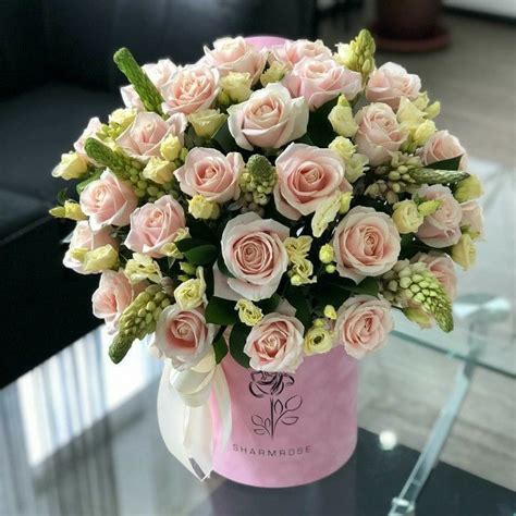 A Vase Filled With Pink Roses On Top Of A Table