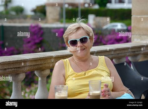 Femme mature assise sur la terrasse Banque de photographies et dimages à haute résolution Alamy