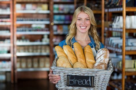 Premium Photo Smiling Female Staff Holding A Basket Of Breads