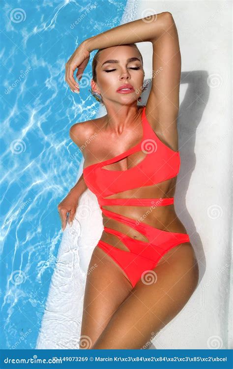 Elegant Woman In The Orange Bikini On The Sun Tanned Slim And Shapely