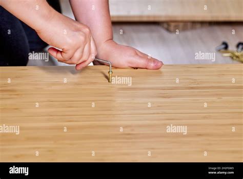 Assembler Installs Flat Pack Furniture Using Screws And Tool Stock