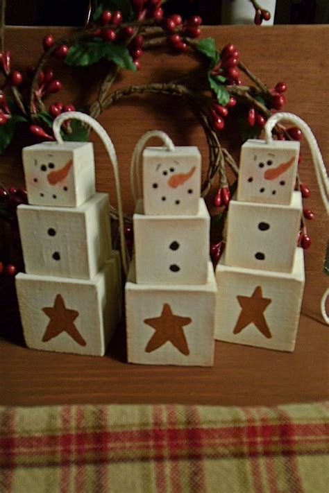 Four Snowmen Made Out Of Wood Blocks On A Table With Christmas