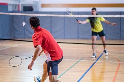 Two Men Playing Tennis On An Indoor Court