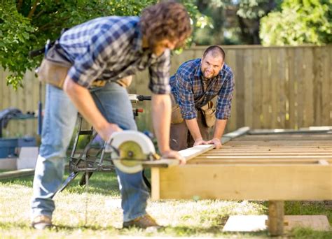 carpenter cutting wood    coworker drilling  site stock