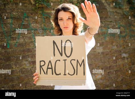 Upset Young Protesting Woman In White Shirt Holds Protest Sign