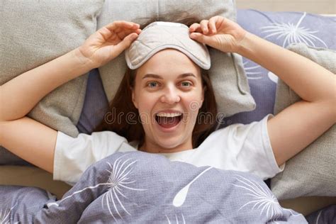 Top View Of Happy Beautiful Young Woman Wearing Sleeping Mask Awake