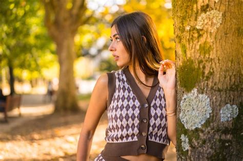 Premium Photo Brunette Model In Autumn At Sunset In A Natural City Park Next To A Tree