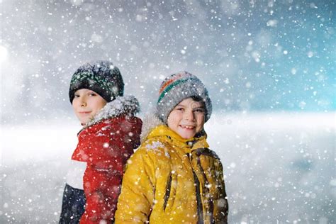 Dos Niños Pequeños De Primaria Caminando Al Colegio Durante La Nevada