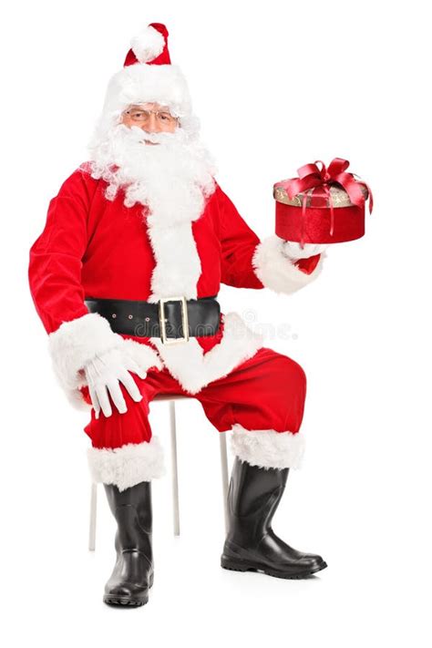 Smiling Santa Claus On A Chair Holding A Present Stock Image Image Of