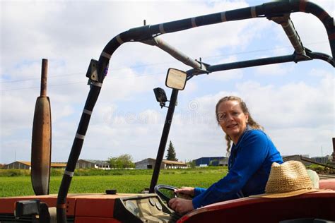 Belle Femme Blonde Fermière Chevauchant Un Tracteur Rouge Pour Cultiver Le Sol Afin De Pouvoir