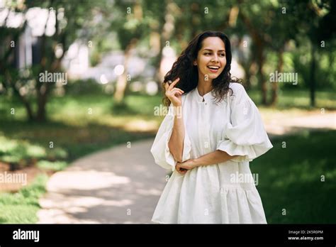 Portrait Of A Beautiful Curly Haired Brunette Girl In The Park Girl Smiling And Holding Her