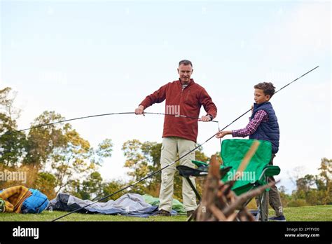 Setting Up Camp A Father And Son Setting Up A Tent Together While