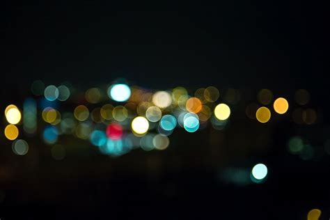 Blurry Image Of City Lights At Night From The Top Of A Hill In The Distance