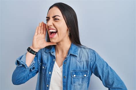 Mujer Hispana De Pie Sobre Fondo Azul Gritando Y Gritando Fuerte A Un