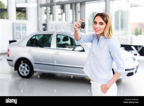 Blonde Business Woman Standing In Modern Car Dealership And Holding Car Key Stock Photo Alamy