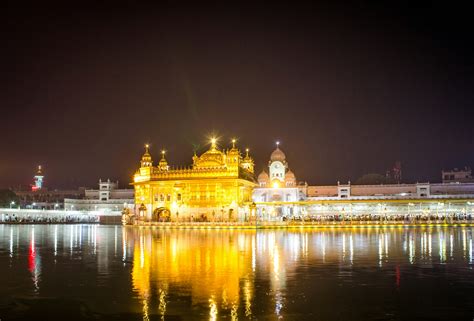 Yellow And White Concrete Building Near Body Of Water During Nighttime Photo Free Amritsar