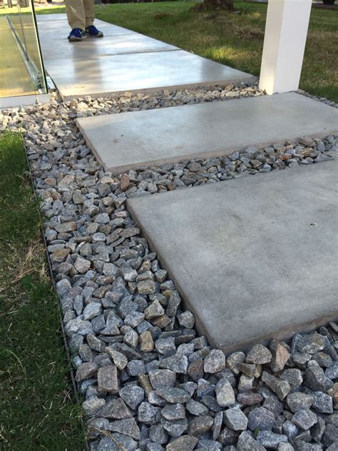 A Person Standing Next To A Walkway Made Out Of Rocks And Stones On The