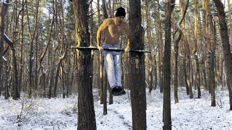 Athletic Guy Doing Push Ups On Horizontal Bar At Winter Forest Hardy