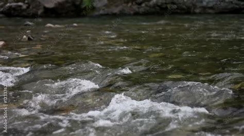 Shot Of The Sacred River Ganges Flowing Past Rocks At The Holy Town Of