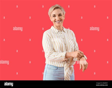 Mature Woman Rolling Up Her Sleeve On Red Background Stock Photo Alamy