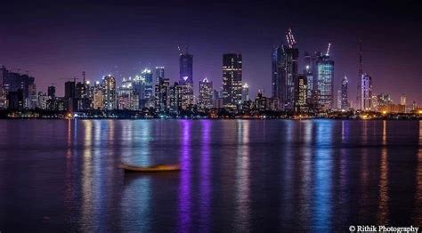 A Boat Floating On Top Of A Body Of Water In Front Of A Large City