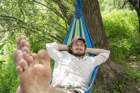 Man Relaxing On Hammock In The Forest Stock Photo