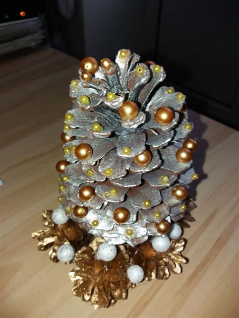 A Pine Cone Decorated With Gold And Silver Ornaments